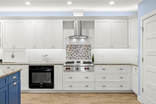 2623 57th St S, Gulfport, FL 33707 - kitchen featuring wall chimney exhaust hood, white cabinets, stainless steel gas cooktop, black oven, and light wood finished floors