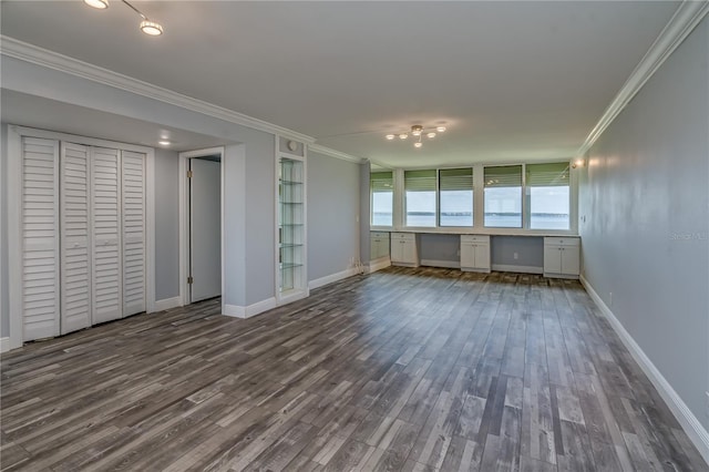 unfurnished living room with baseboards, built in features, ornamental molding, built in study area, and dark wood-style floors