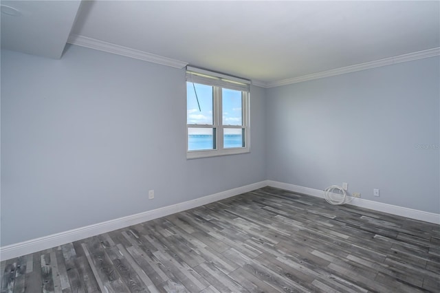 unfurnished room featuring baseboards, crown molding, and dark wood finished floors