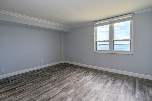 unfurnished room featuring crown molding, baseboards, and dark wood finished floors