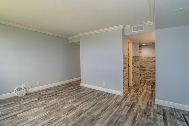 unfurnished room with visible vents, ornamental molding, and wood finished floors