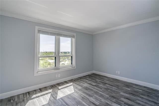 empty room with crown molding, dark wood-style flooring, and baseboards