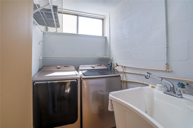 laundry room featuring laundry area, a sink, and concrete block wall