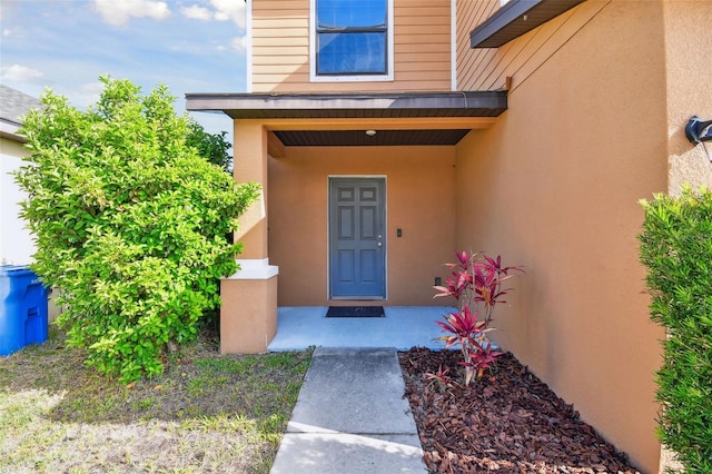 doorway to property featuring stucco siding