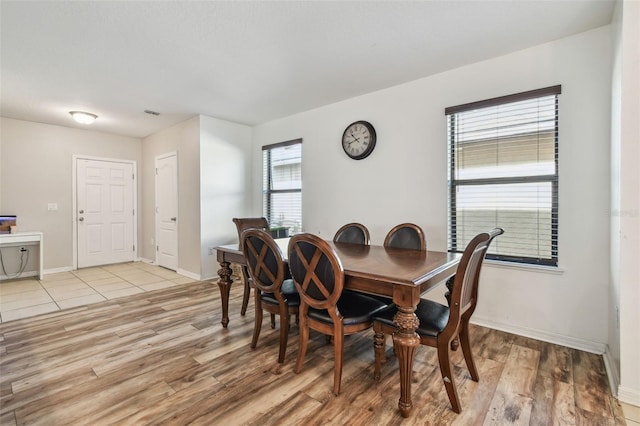 dining area with light wood-style flooring and baseboards