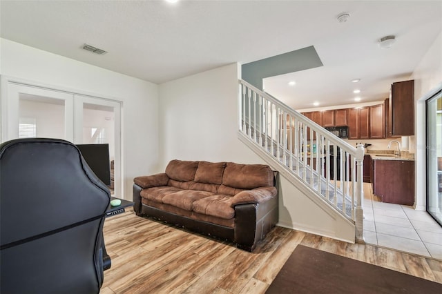 living room featuring recessed lighting, stairway, french doors, visible vents, and light wood finished floors