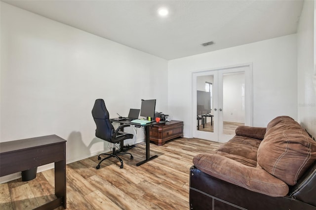 office with french doors, light wood-style flooring, and visible vents