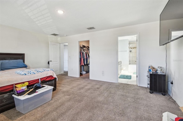 carpeted bedroom featuring visible vents, baseboards, a walk in closet, and a closet