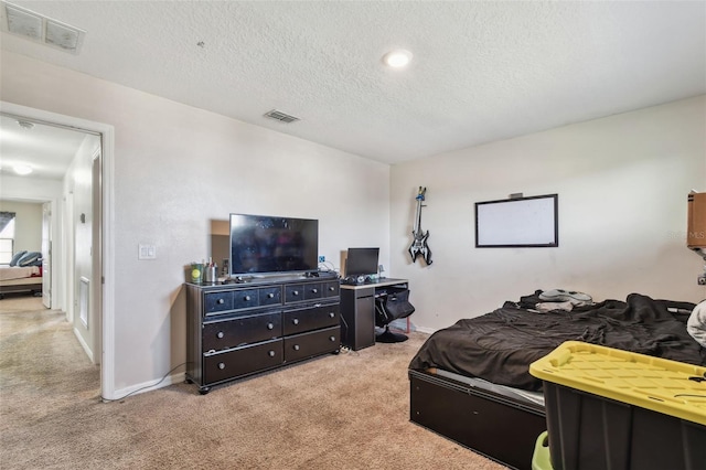 bedroom with visible vents, a textured ceiling, baseboards, and carpet floors