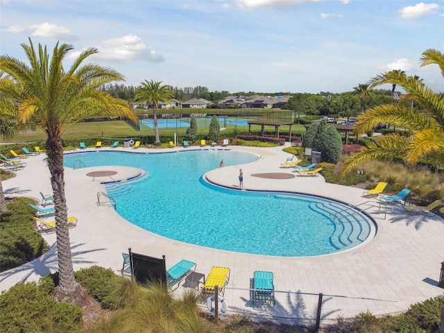 community pool featuring fence and a patio