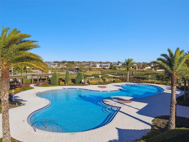 pool with a patio and fence