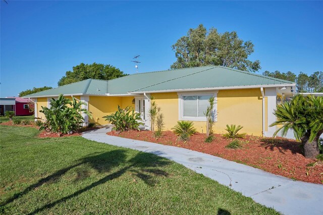 6589 Banyan Dr, Indian Lake Estates, FL 33855 - view of front facade featuring a front yard and stucco siding