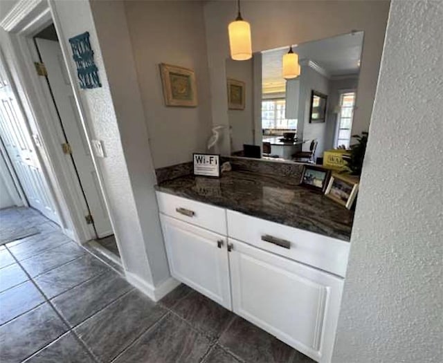 5430 Avenida Del Mare, Sarasota, FL 34242 - bar area featuring a textured wall, dark tile patterned flooring, decorative light fixtures, and crown molding