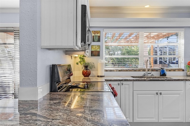 5430 Avenida Del Mare, Sarasota, FL 34242 - kitchen featuring ornamental molding, white cabinetry, stainless steel range with electric stovetop, a textured wall, and dark stone counters