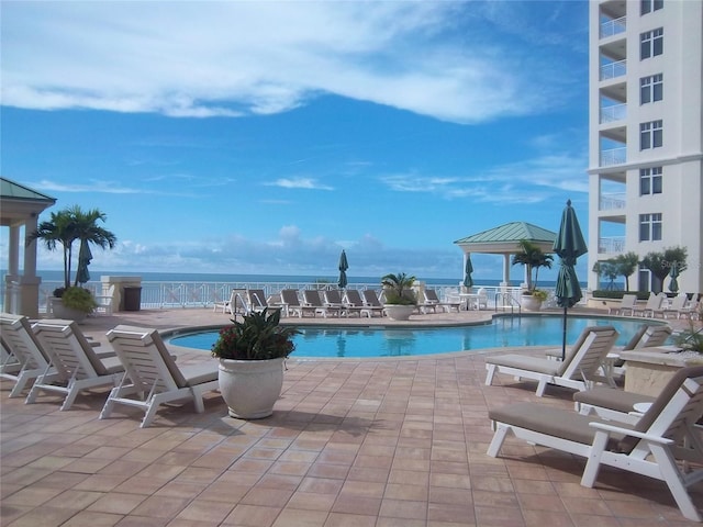 community pool with a gazebo and a patio