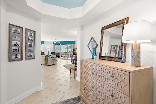 corridor featuring baseboards and light tile patterned floors