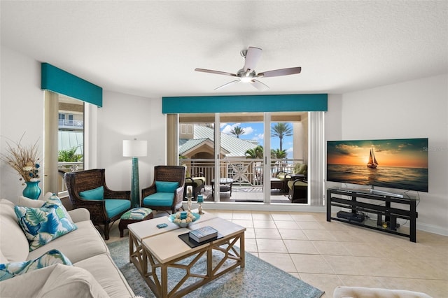 living area featuring ceiling fan, light tile patterned floors, and baseboards