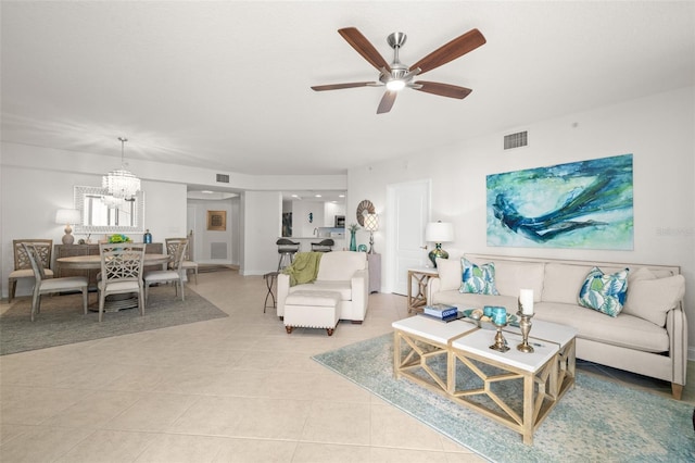 living room with a ceiling fan, light tile patterned floors, and a chandelier