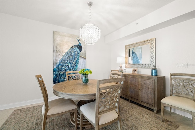 dining space with a chandelier, light tile patterned floors, and baseboards