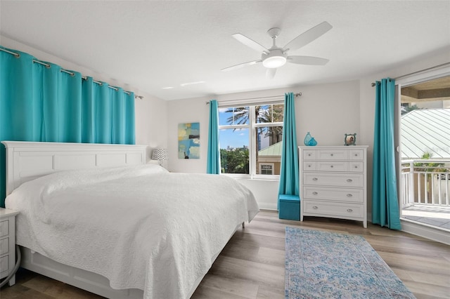 bedroom with access to exterior, a ceiling fan, and wood finished floors