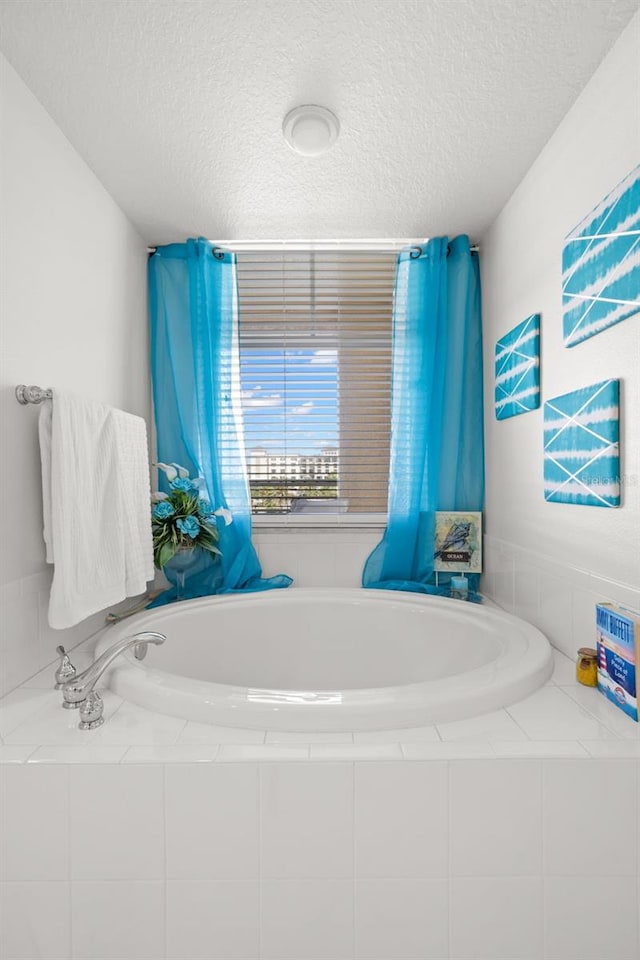 bathroom featuring a textured ceiling and a bath