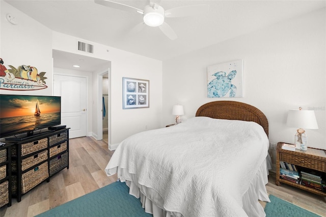 bedroom with light wood-style floors, ceiling fan, and baseboards