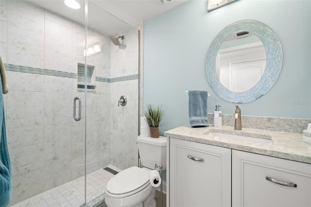 bathroom featuring a stall shower, toilet, and vanity