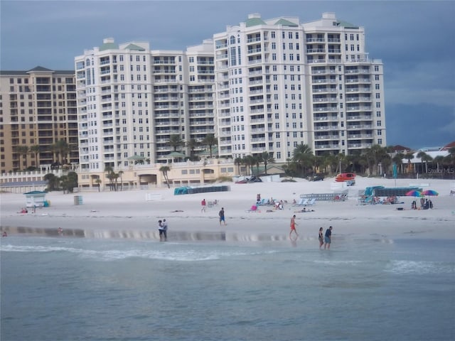 view of apartment building / complex featuring view of water and beach