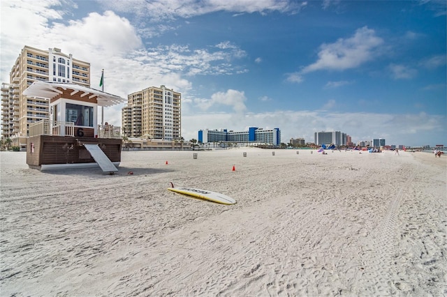 surrounding community with a beach view and a view of city
