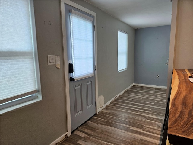 doorway to outside featuring wood finished floors and baseboards