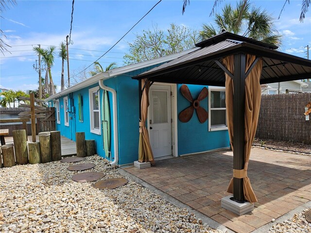 view of front of home featuring a gazebo, a patio area, and fence