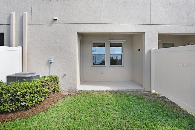 exterior space with stucco siding, central air condition unit, fence, and a patio area