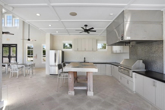 interior space with exterior kitchen, outdoor dining space, a ceiling fan, a grill, and a sink