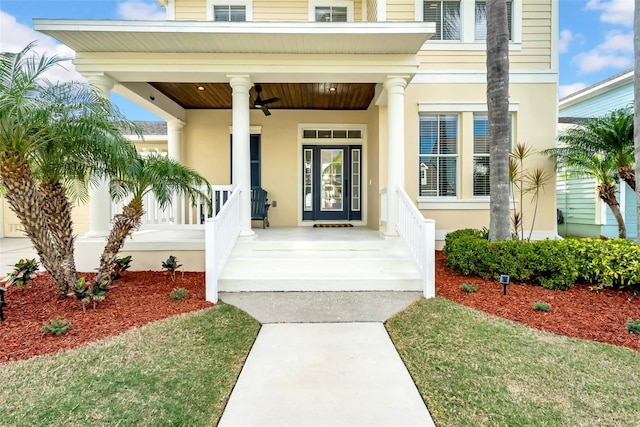 entrance to property featuring covered porch and stucco siding