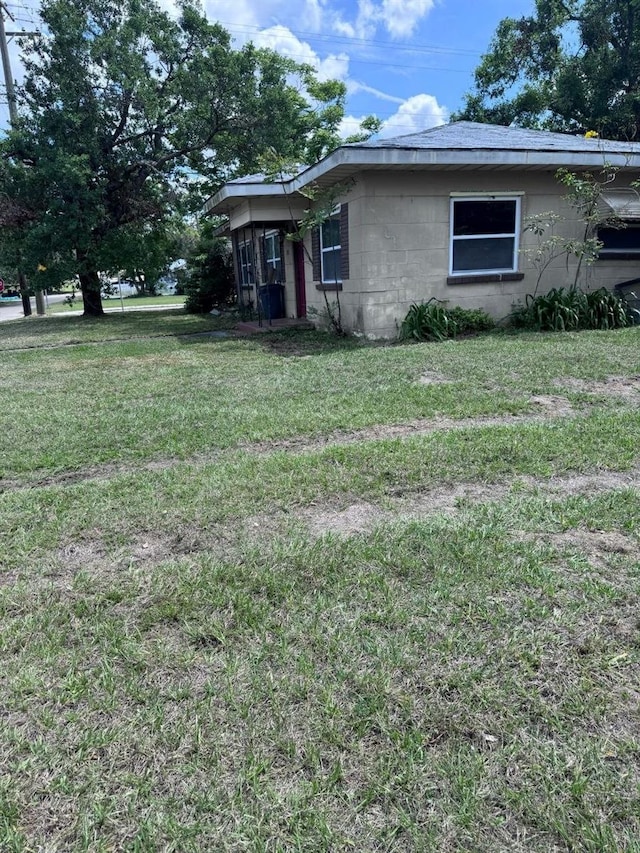 1211 NE 4th St, Mulberry, FL 33860 - view of side of property with concrete block siding and a yard
