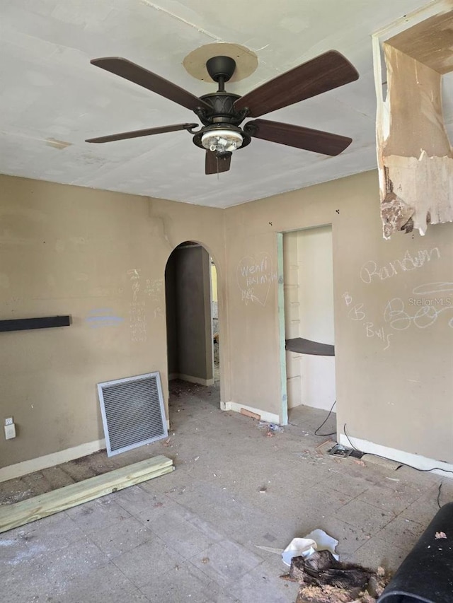 1211 NE 4th St, Mulberry, FL 33860 - unfurnished living room featuring arched walkways, a ceiling fan, and baseboards