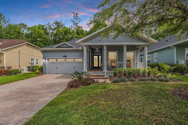 19529 Lily Pond Ct, Brooksville, FL 34601 - view of front of house with stucco siding, a lawn, a porch, decorative driveway, and a garage