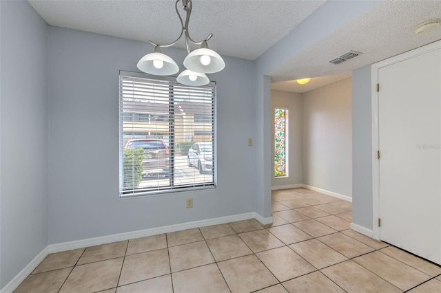 1424 Highland Ridge Cir, Brandon, FL 33510 - empty room with visible vents, baseboards, light tile patterned floors, an inviting chandelier, and a textured ceiling
