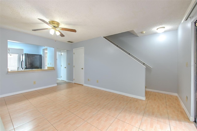 1424 Highland Ridge Cir, Brandon, FL 33510 - unfurnished living room featuring visible vents, ceiling fan, baseboards, and a textured ceiling