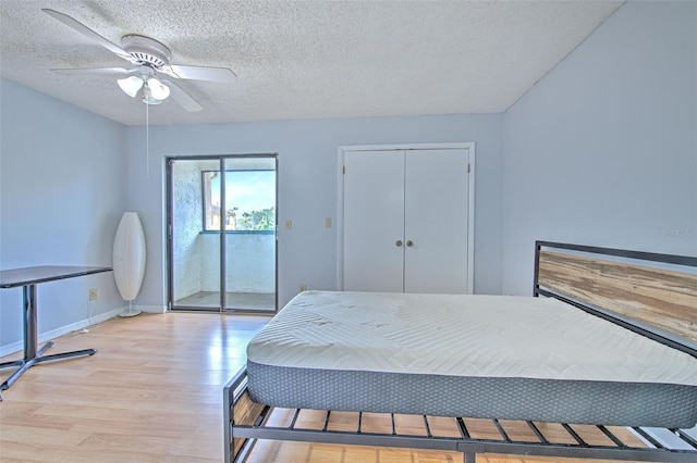 1424 Highland Ridge Cir, Brandon, FL 33510 - bedroom featuring baseboards, light wood-type flooring, a textured ceiling, and ceiling fan