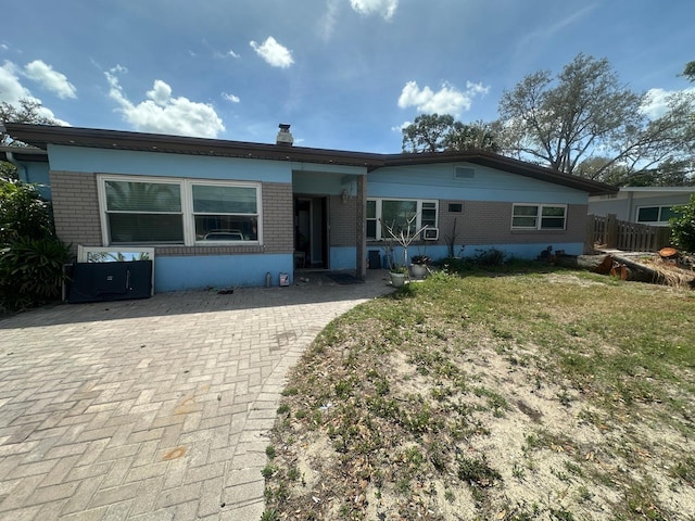 back of property featuring brick siding and a yard