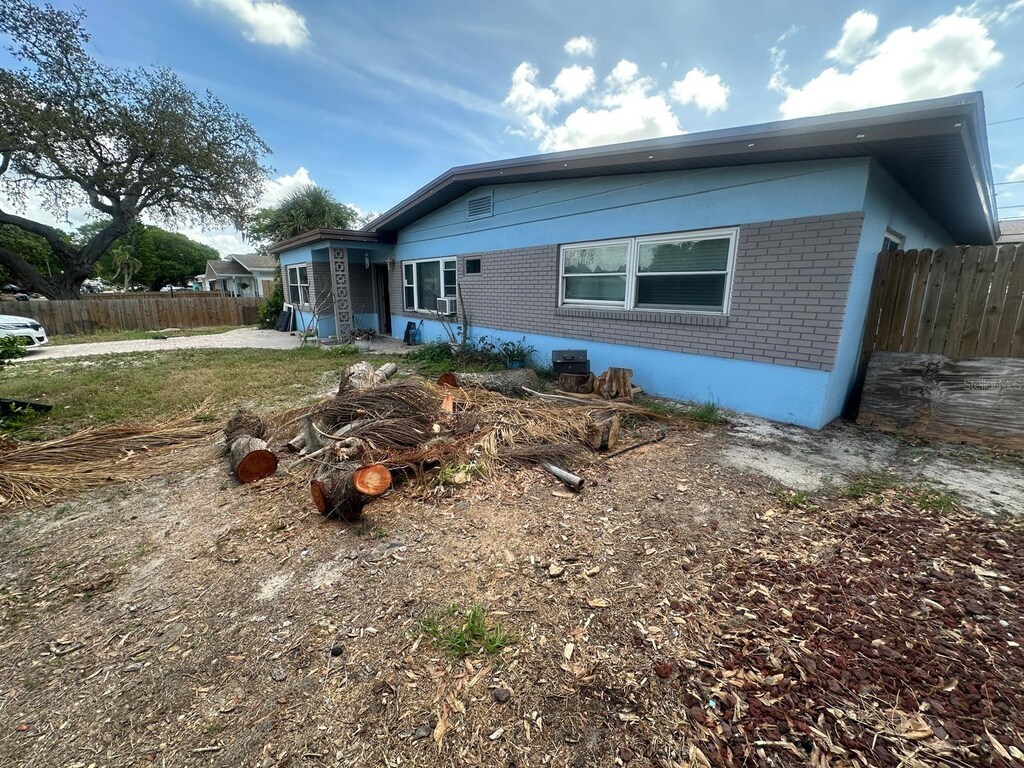 rear view of house featuring fence and brick siding