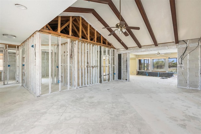 misc room with a ceiling fan and vaulted ceiling with beams