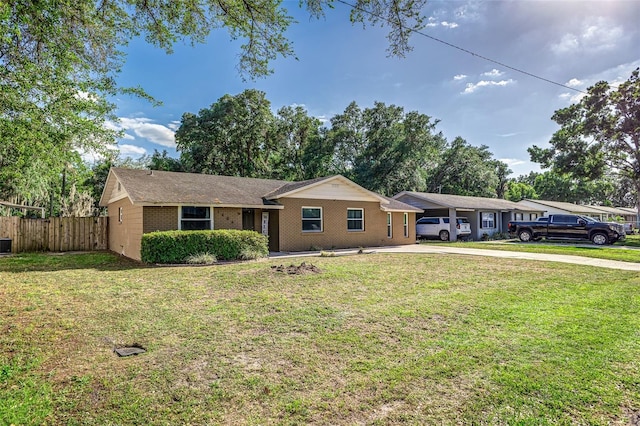 ranch-style house featuring driveway, a front yard, fence, and brick siding