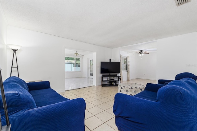 living area with a ceiling fan, light tile patterned floors, a textured ceiling, and visible vents