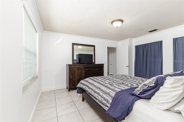 bedroom featuring light tile patterned floors, a textured ceiling, baseboards, and visible vents