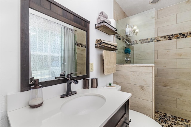 bathroom with toilet, vanity, and walk in shower