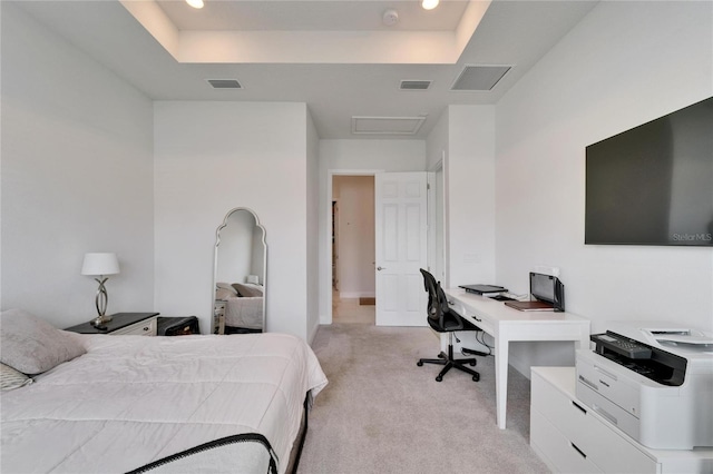 bedroom featuring a tray ceiling, light carpet, and visible vents