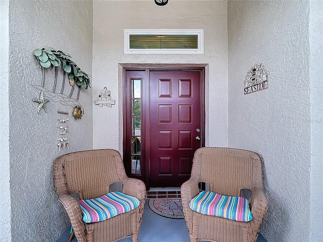 property entrance featuring visible vents and stucco siding