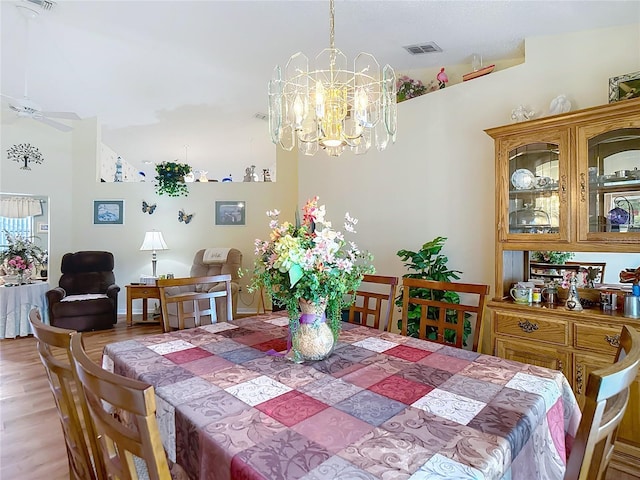 dining room featuring ceiling fan with notable chandelier, visible vents, and light wood-style flooring